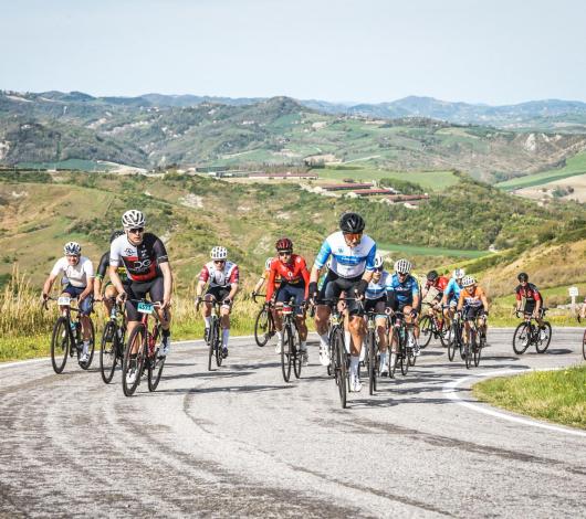 Ciclisti su strada collinare durante una gara.