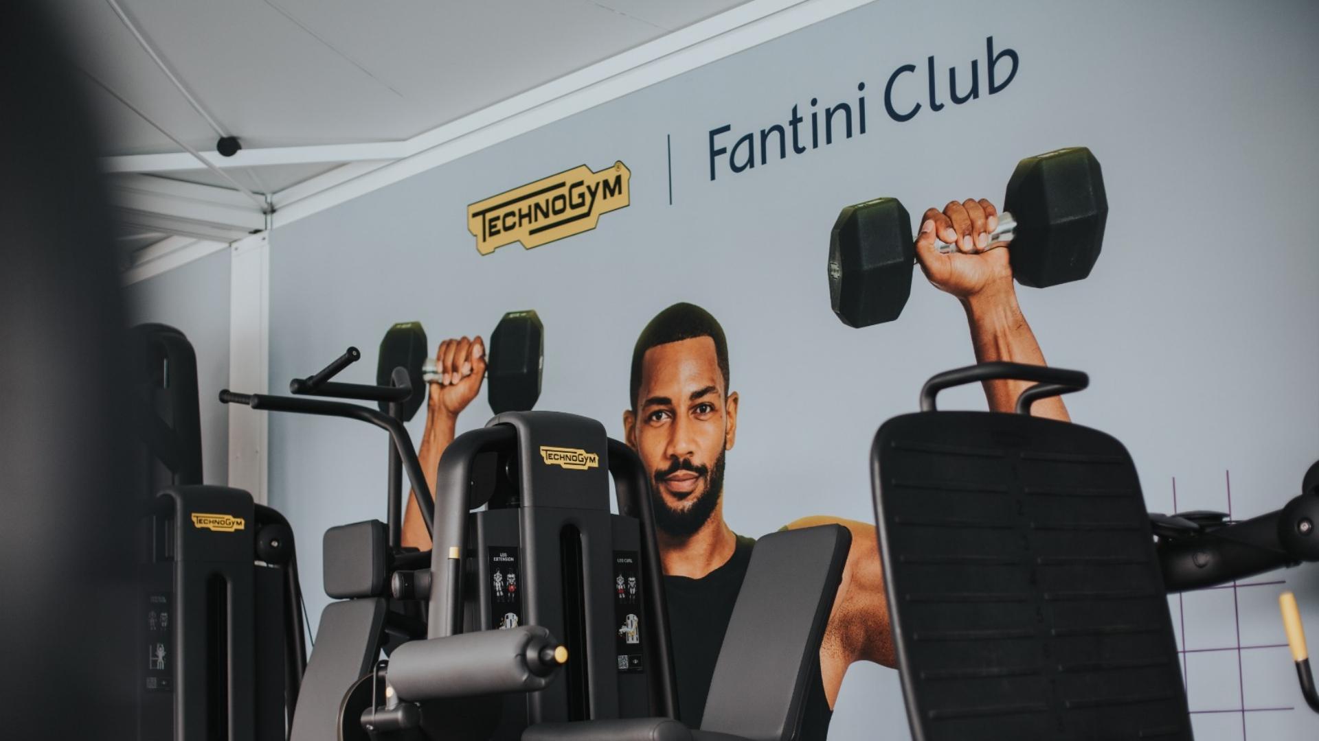 Attrezzature Technogym in palestra Fantini Club con immagine di uomo che solleva pesi.