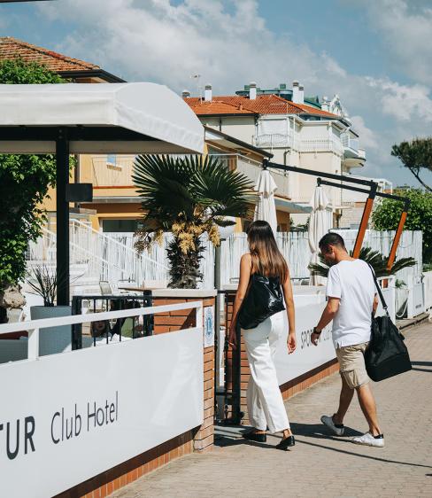 Due persone entrano in un hotel vicino alla spiaggia in una giornata soleggiata.