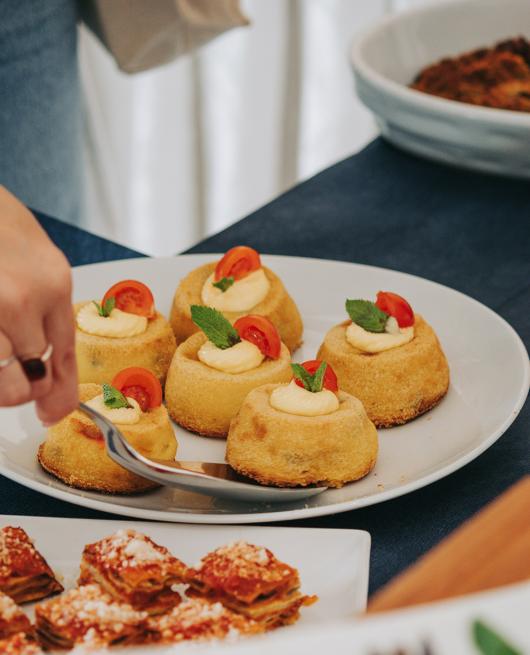 Dolci con crema e pomodorini, decorati con foglie di menta su un piatto bianco.